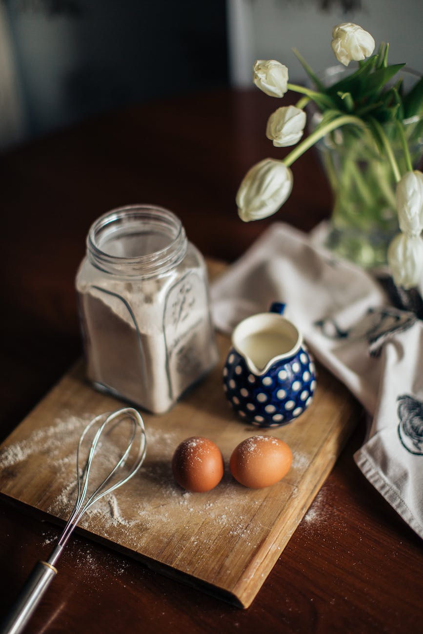 fresh ingredients and tulips in vase on kitchen table